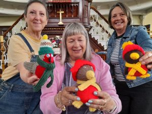 Three ladies with knitted Robins for the Christmas Tree Festival